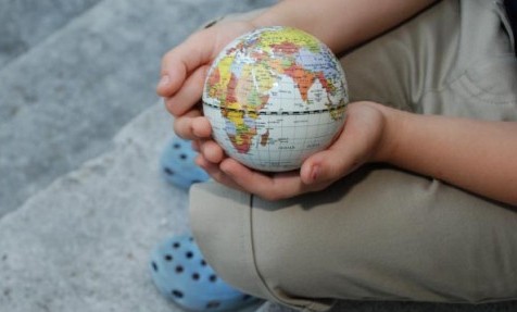 child holding globe - sustainability